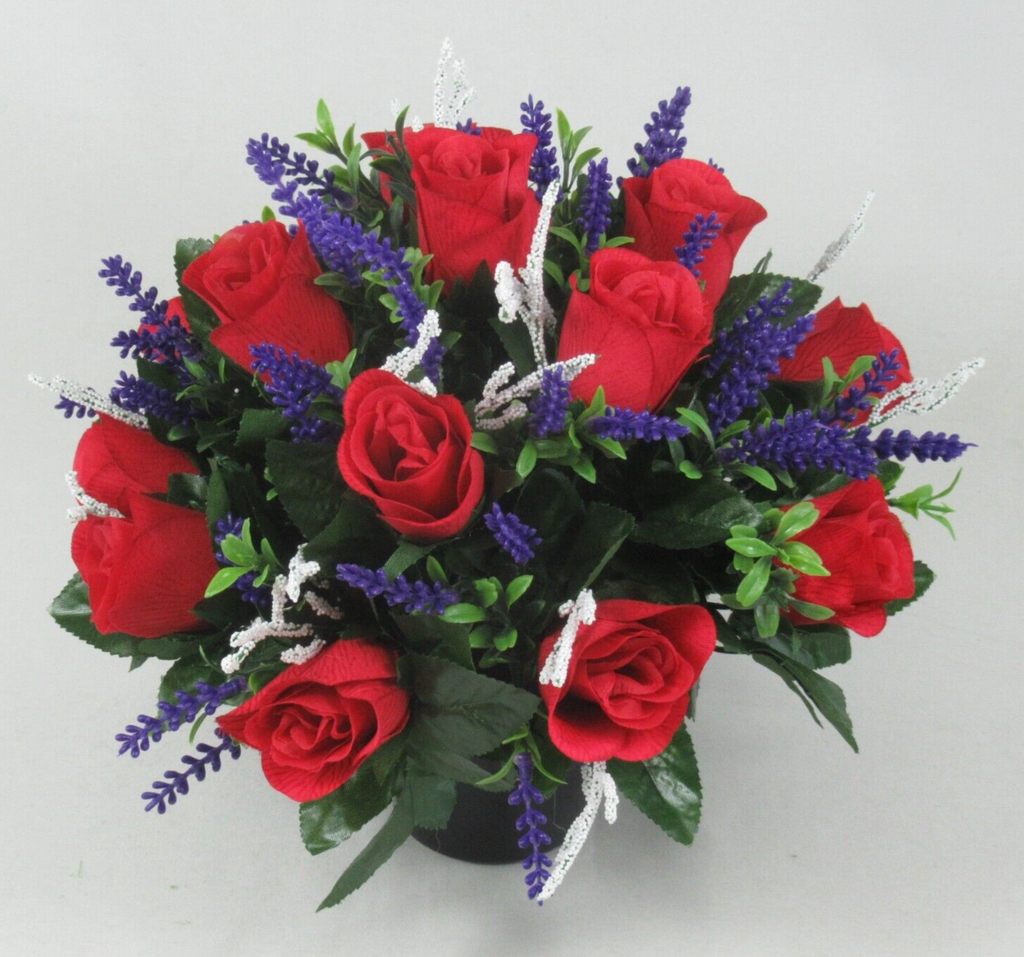 Close view memorial grave arrangement: red roses with purple spikes and silver-white ribbon stems