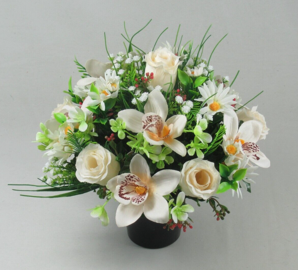 Artificial memorial cremation pot bouquet with white flowers, green leaves, and small red berries