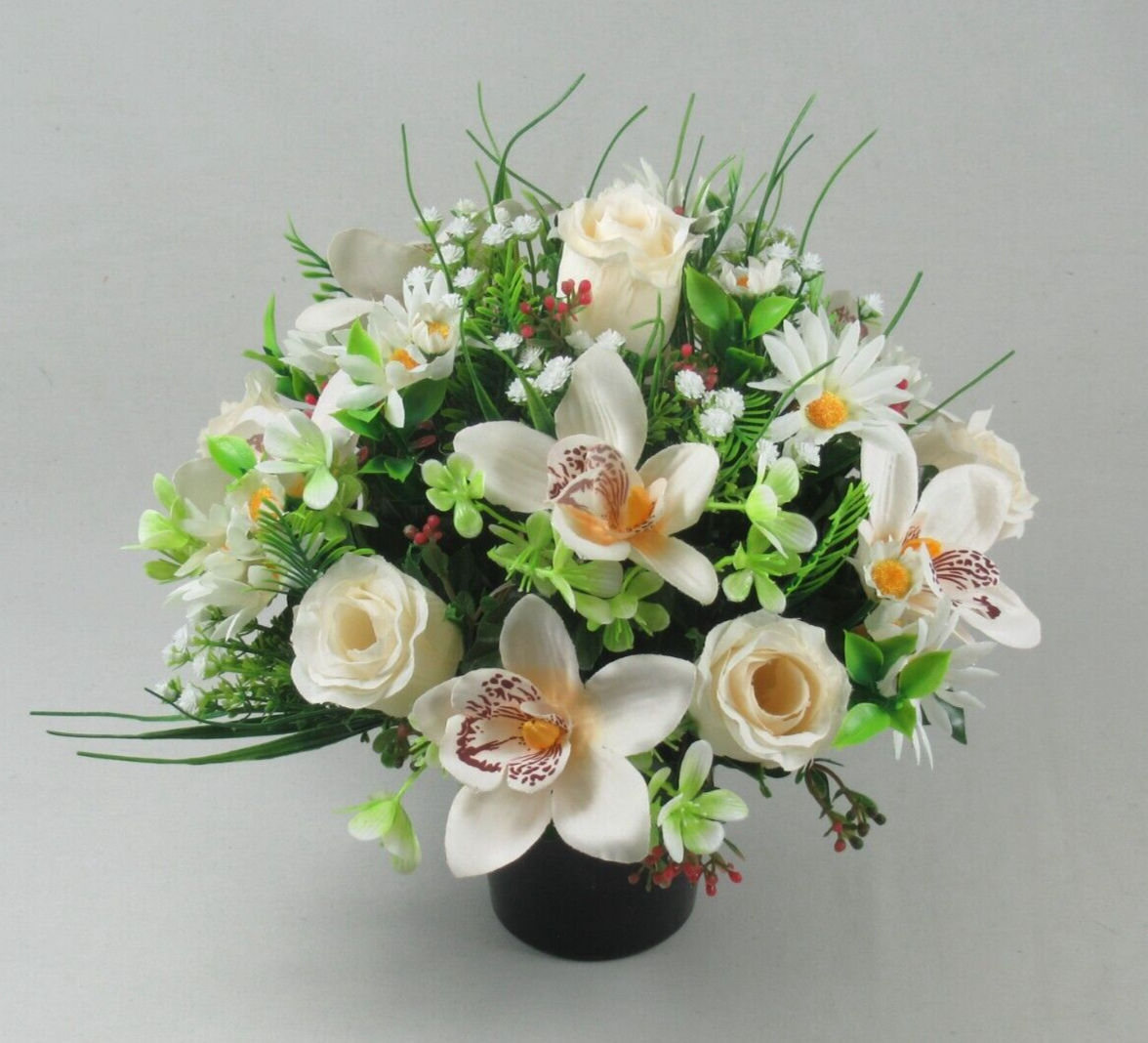 Artificial memorial cremation pot bouquet with white flowers, green leaves, and small red berries