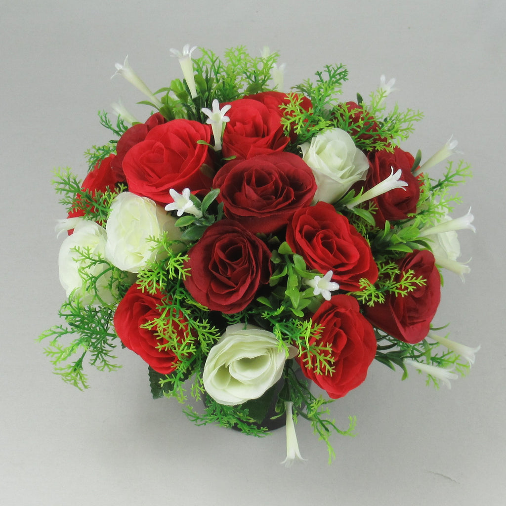 Red and ivory artificial roses with green foliage in a memorial pot, viewed from above
