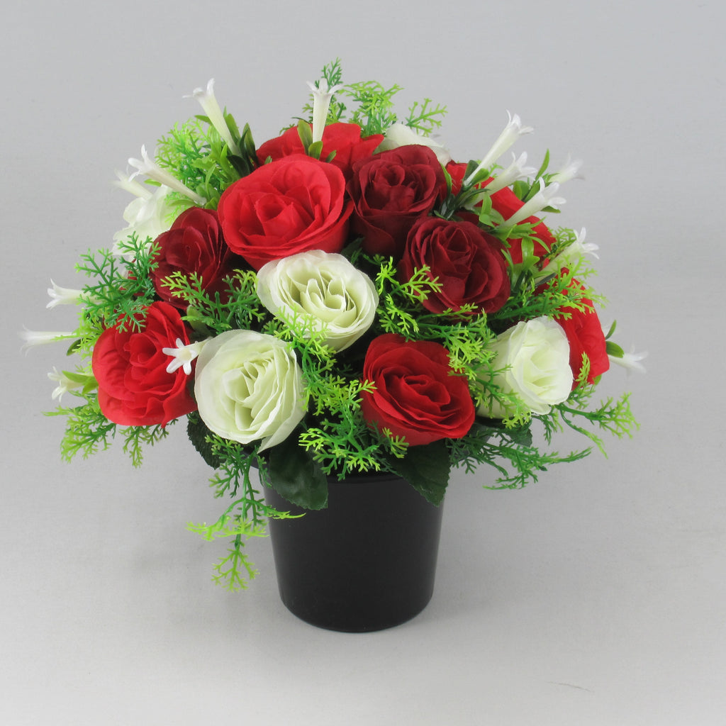 Artificial red and ivory rose arrangement with greenery in a black memorial pot