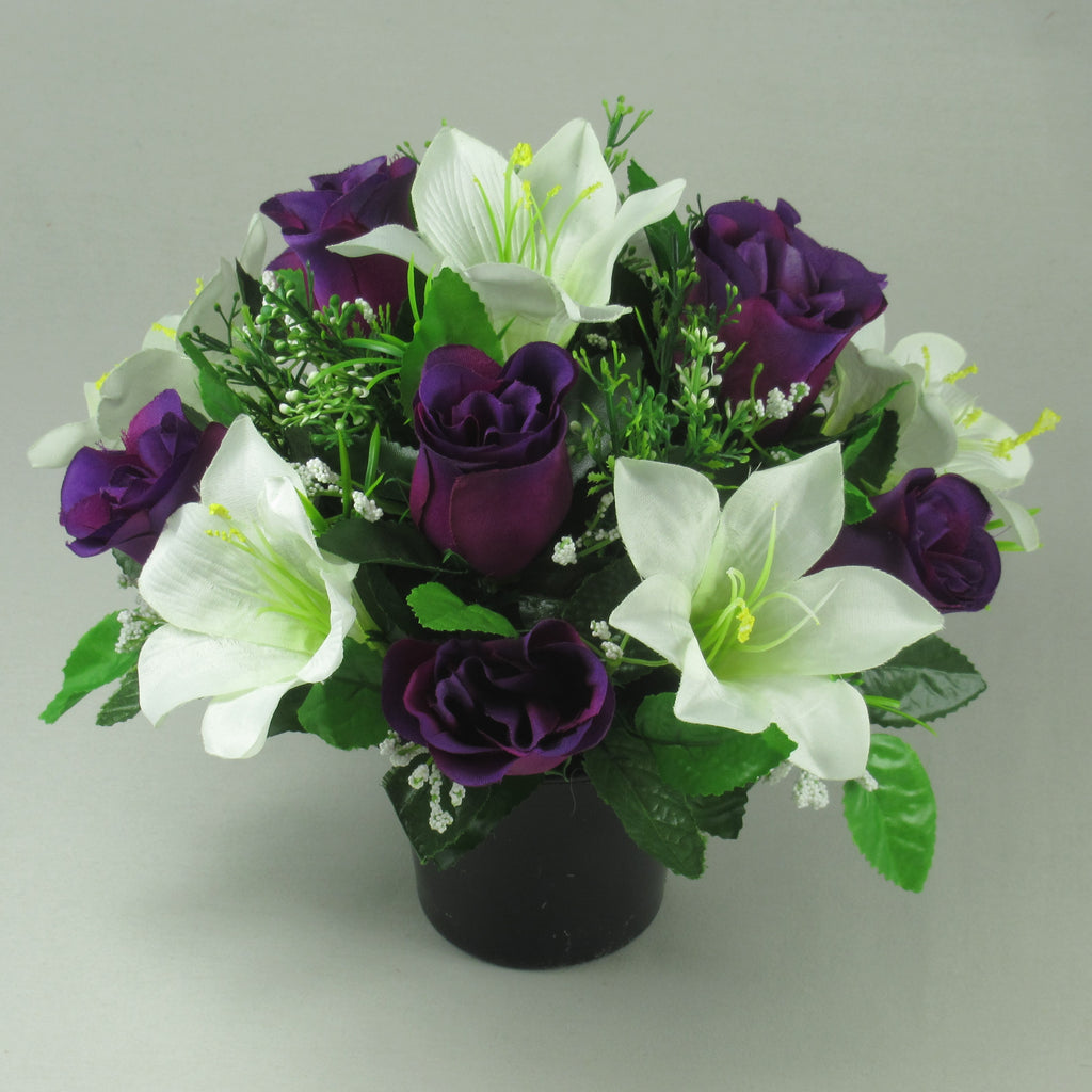 Artificial silk flower arrangement in black pot with purple roses, white lilies, green leaves