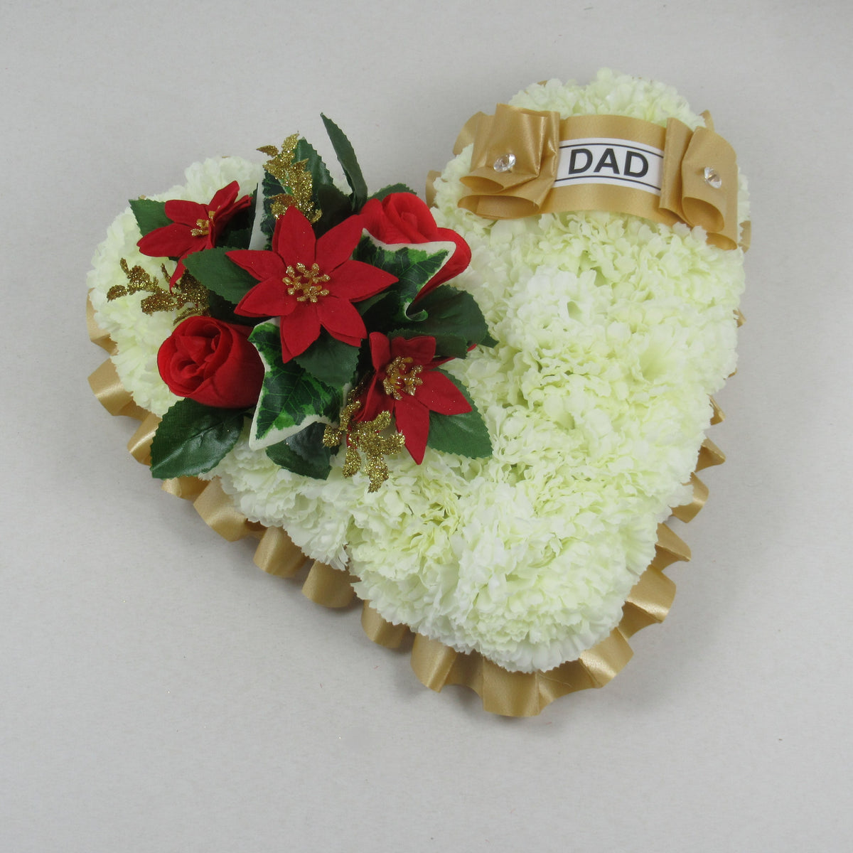 Heart-shaped memorial wreath with white flowers, red poinsettia accents, and gold “DAD” ribbon